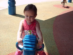 A blind child playing on a rocking elepahant at park day